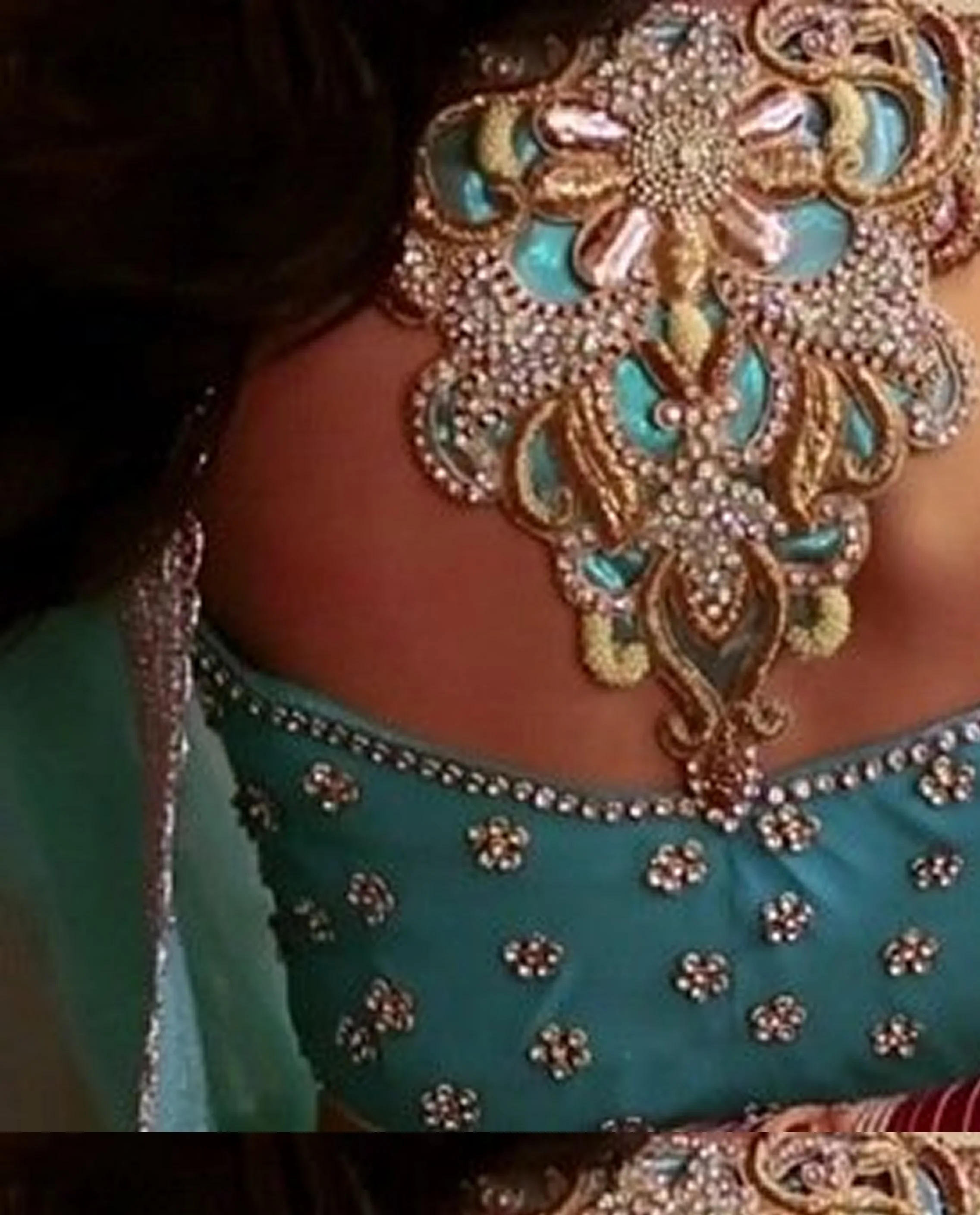 Intricate embroidery detail on a teal saree